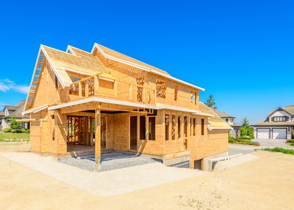 New construction home framed under a clear sky