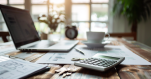 Calculator and home buying documents showing closing cost savings from buyer commission rebate Colorado