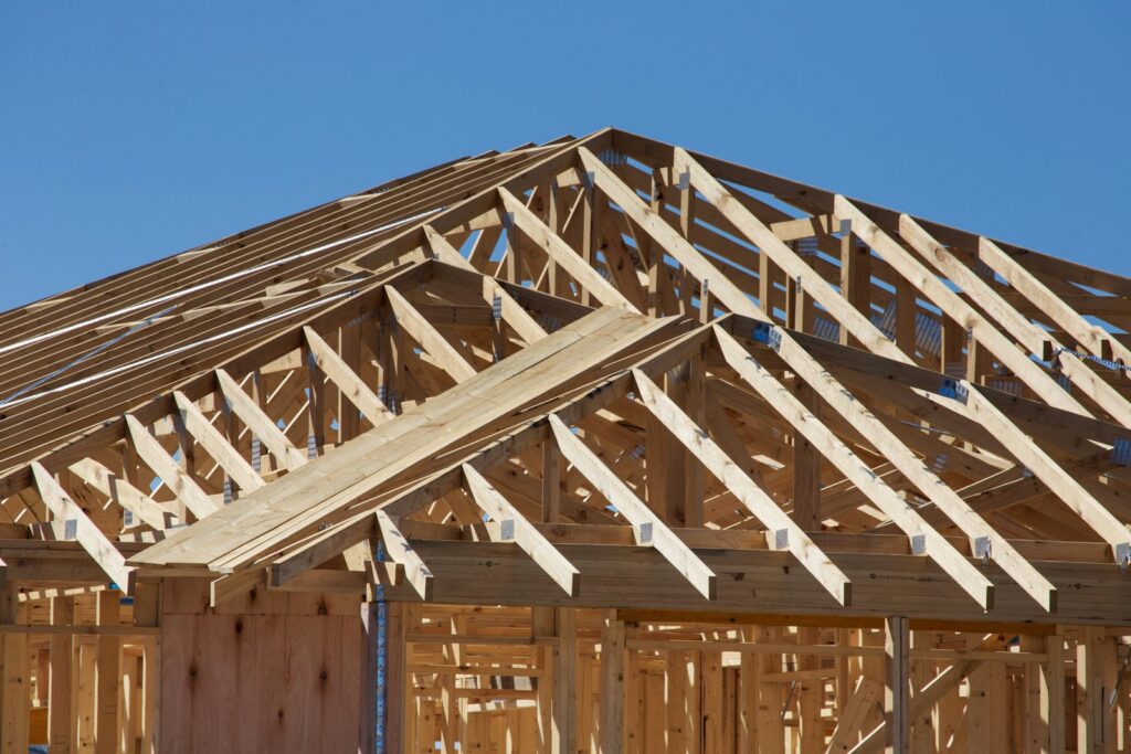 Roof and wall framing on a new construction home under a clear Colorado sky
